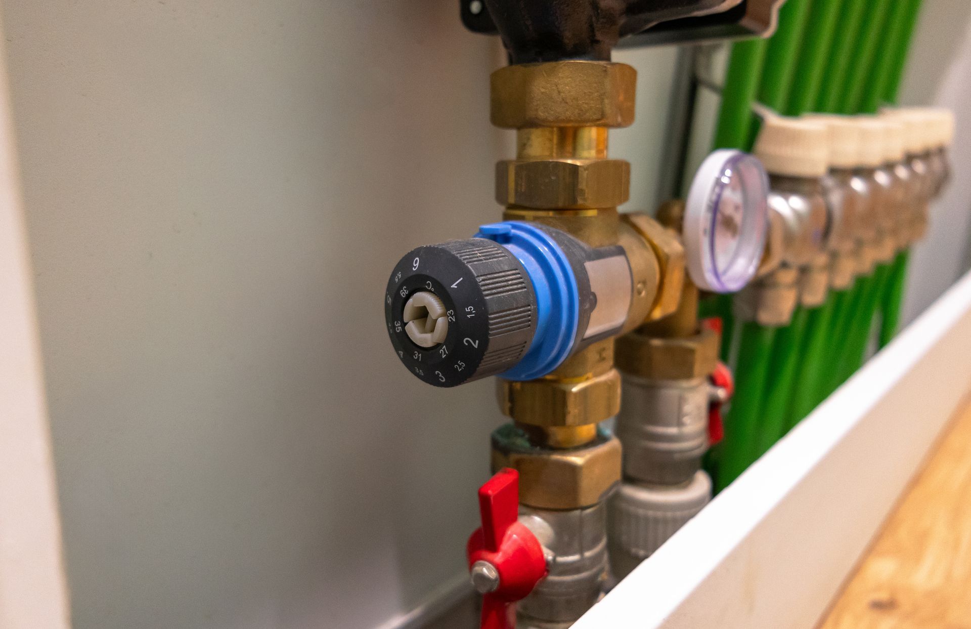 Plumber using a drain snake under a kitchen sink in a Louisiana home — plumbing services in Benton, LA