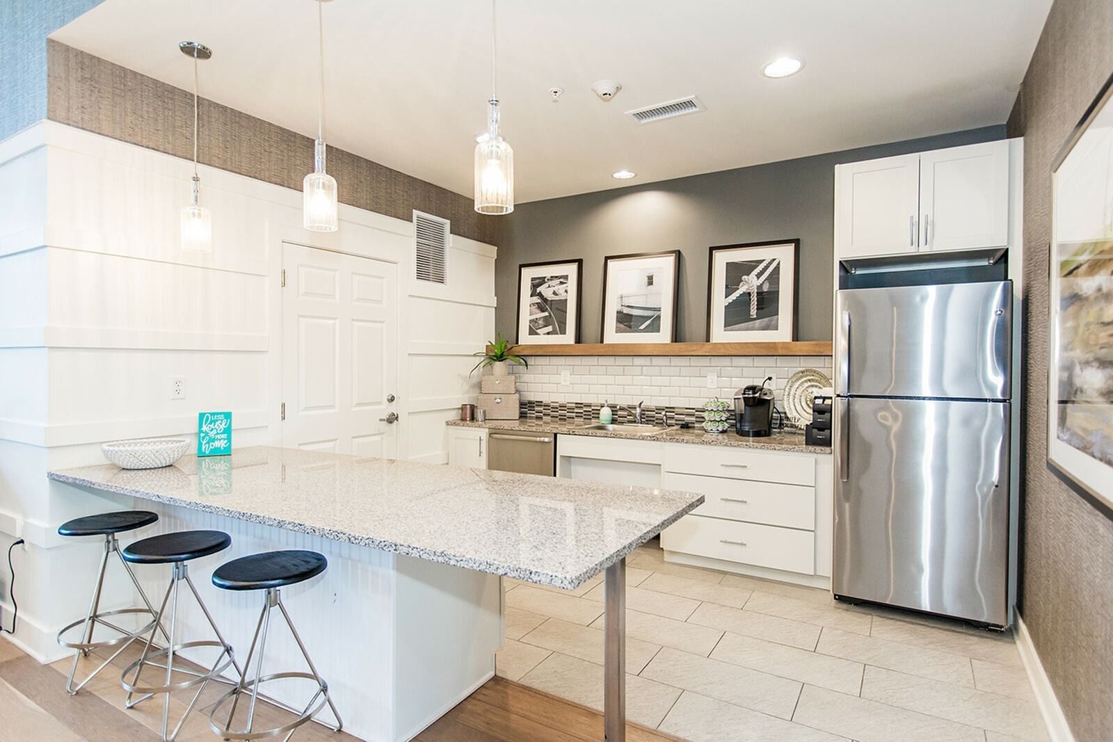 The Reserve at Stoney Creek clubhouse ktichen with oversized island, modern design, and white cabinets. 
