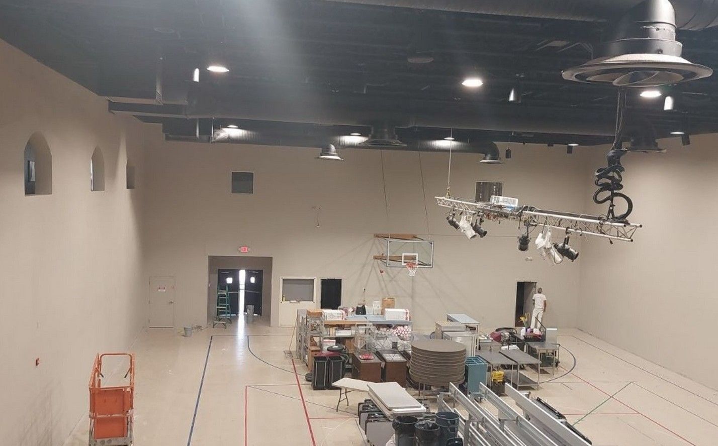 Empty construction room with recessed lights, tools, and equipment scattered on the floor