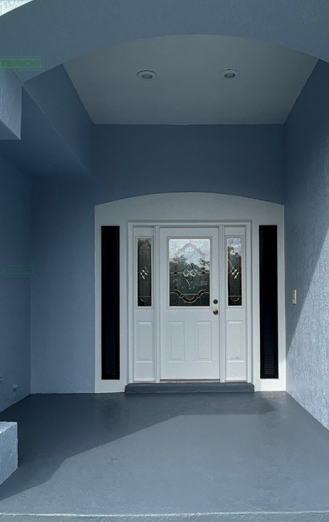 Front entry with white double doors, sidelights, and blue walls in a covered porch entryway