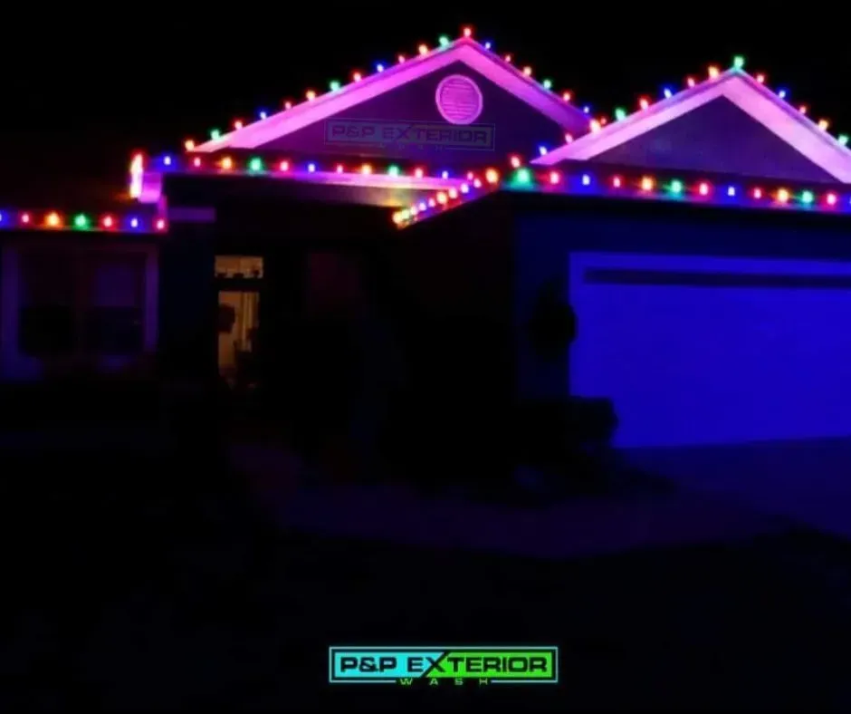 House at night with colorful Christmas lights glowing along the roofline