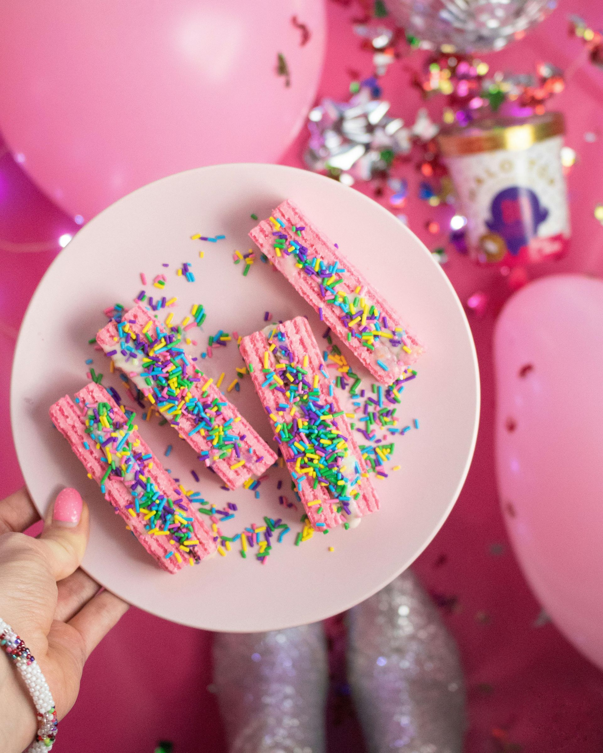 A person is holding a plate of food with sprinkles on it