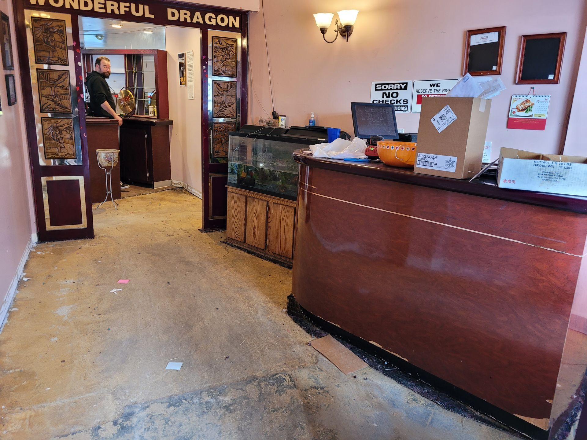Restaurant entrance and host stand with wooden counter, doorway, and warm lighting