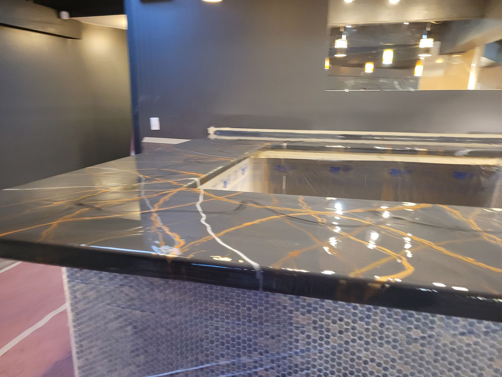 Black marble bar or countertop with gold veining in a modern interior