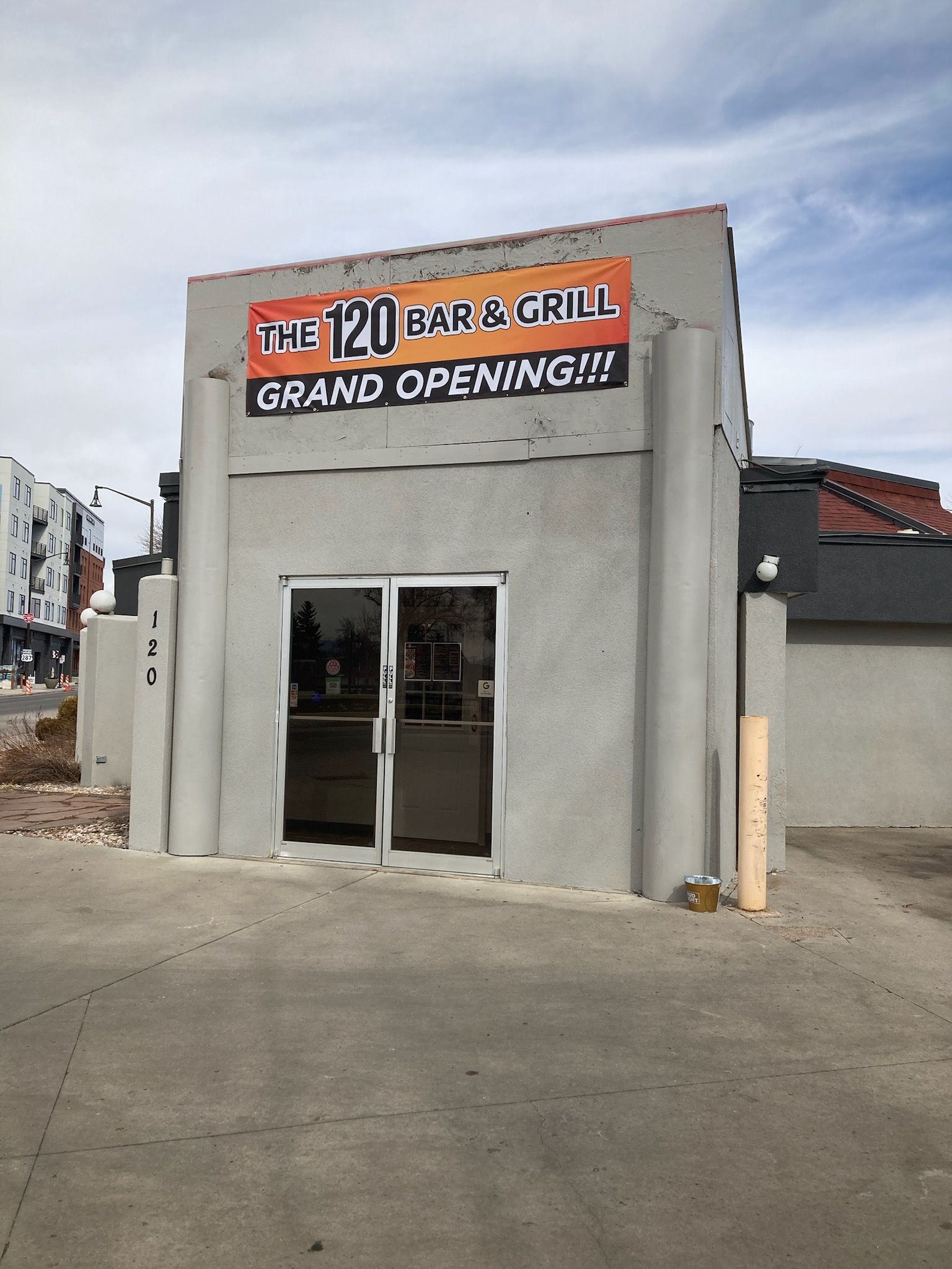 Small storefront with a “Grand Opening” sign above the glass entrance.