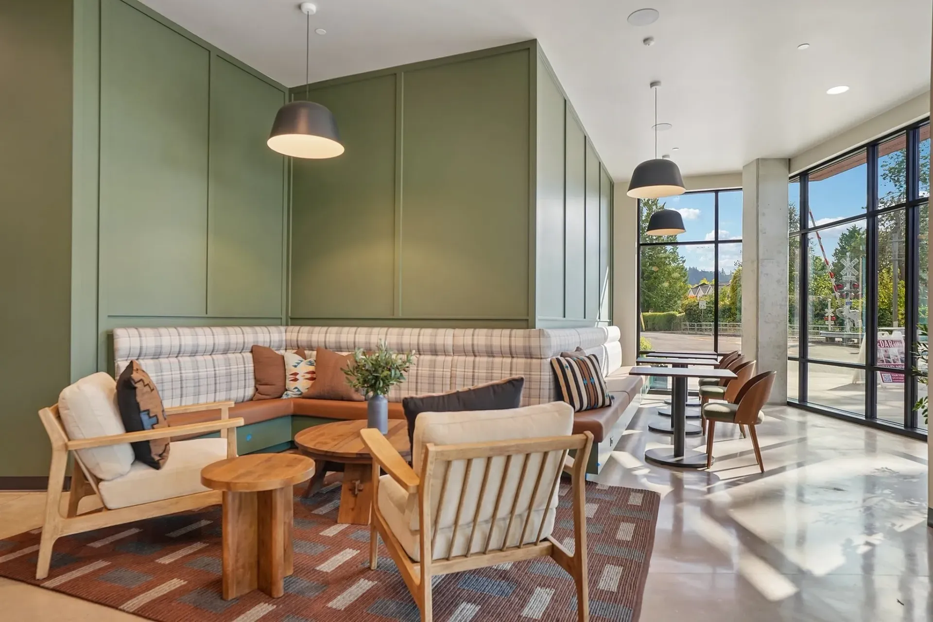 Lounge area with green accent wall, banquette seating, and modern chairs.