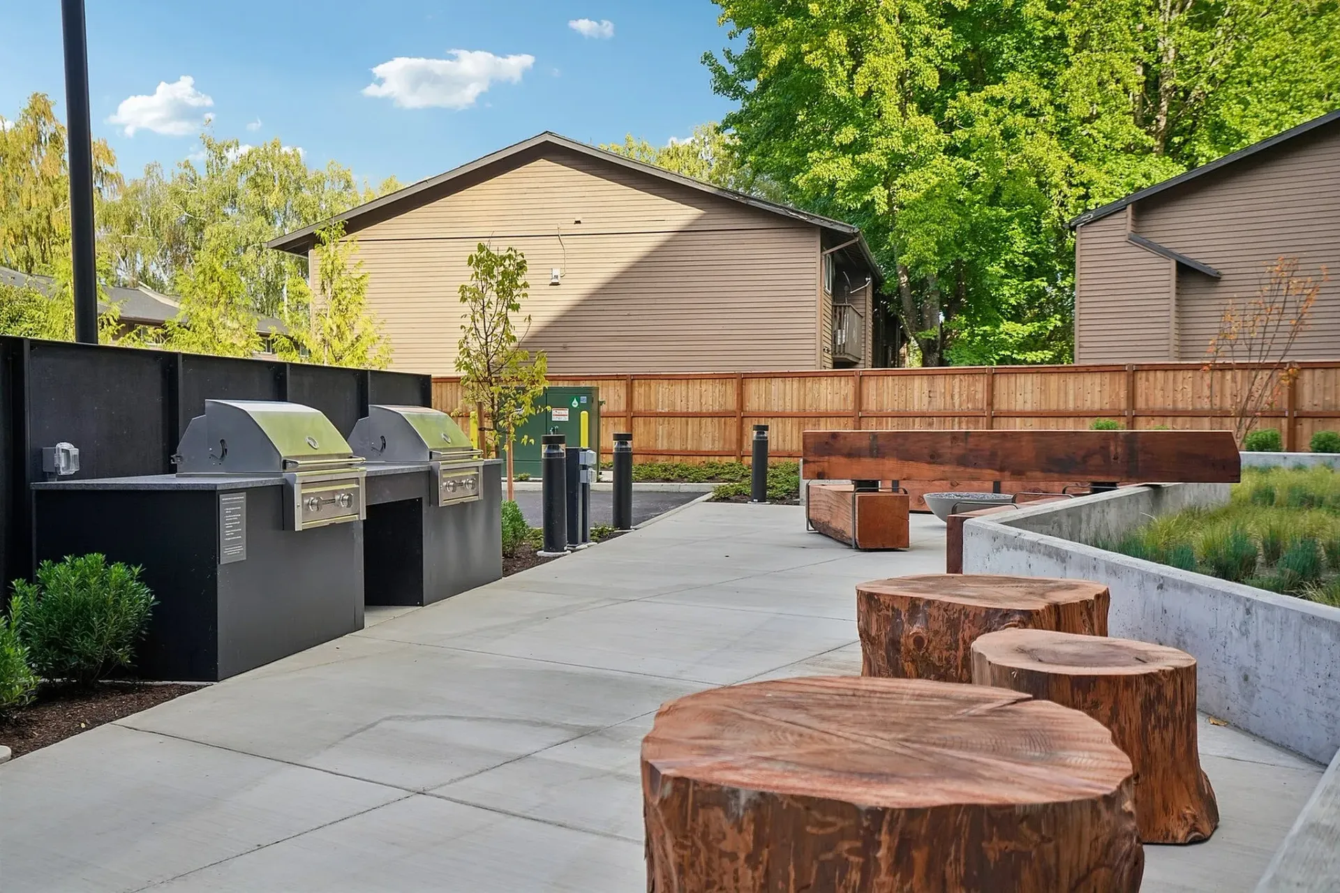 Outdoor grills and seating area with tree stump tables.
