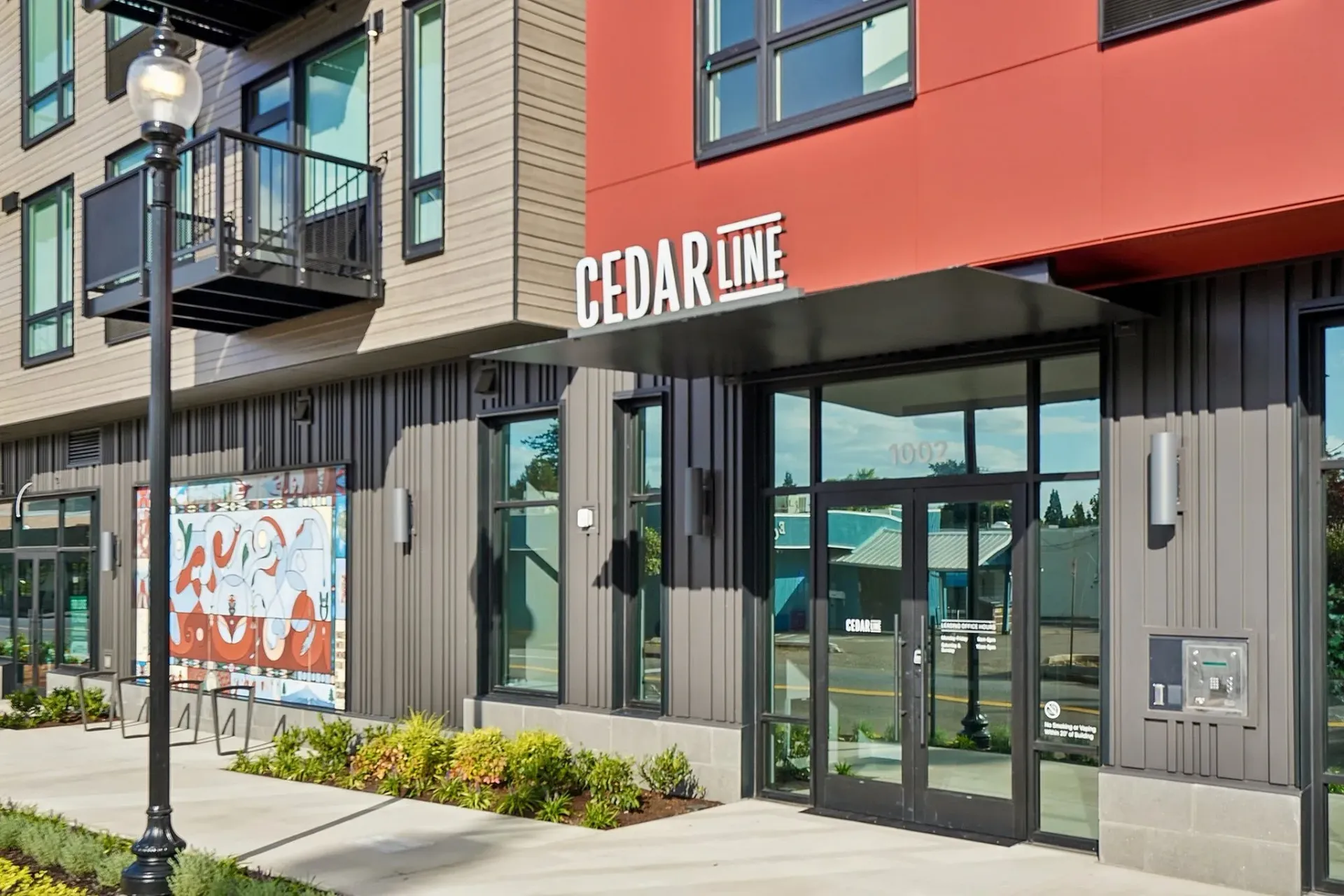 Cedar Line apartment building entrance with modern architecture and colorful mural.