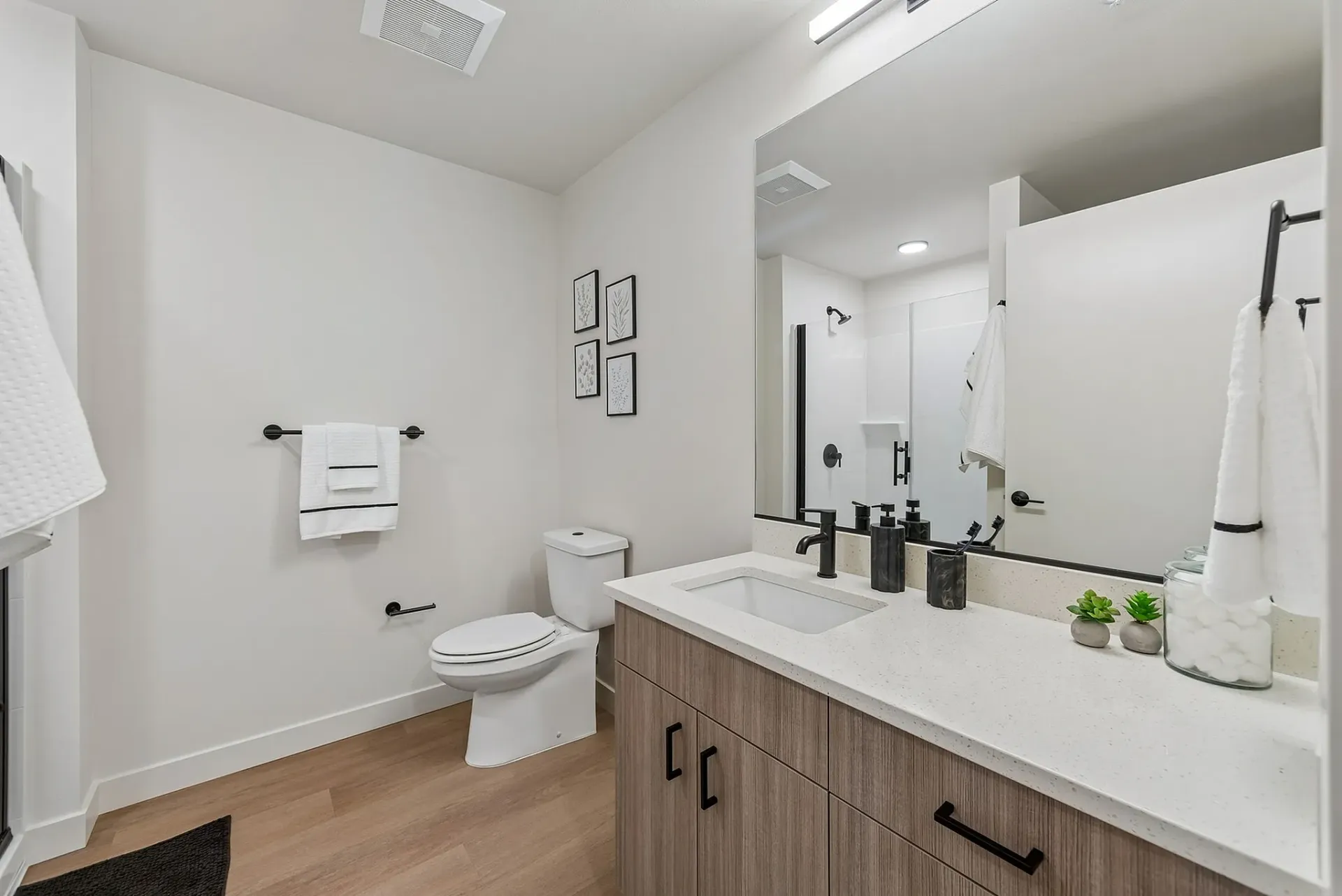 Modern bathroom with vanity, toilet, and shower.