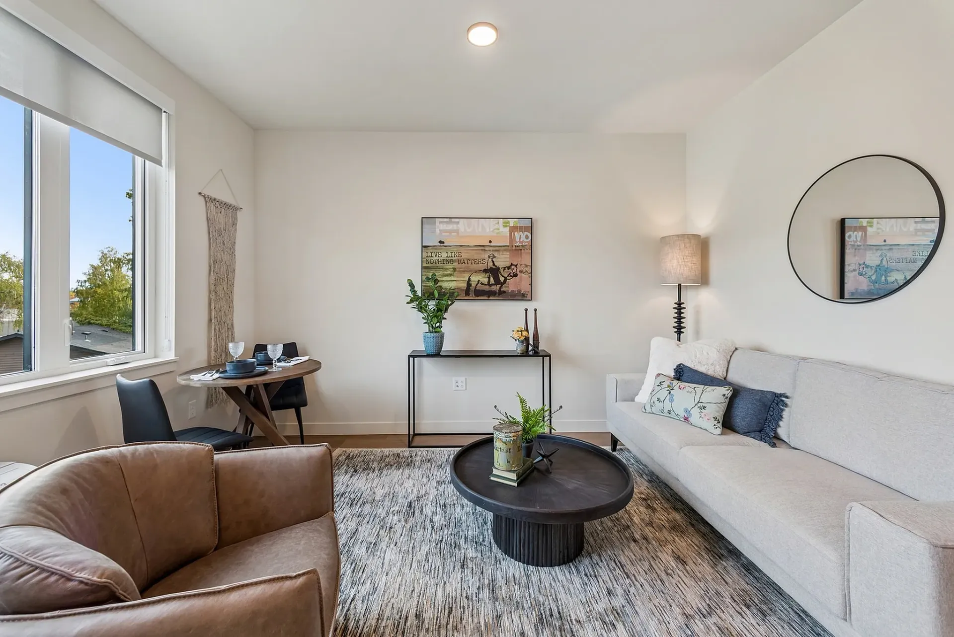 Modern living room with a sofa, armchair, coffee table, and dining set.