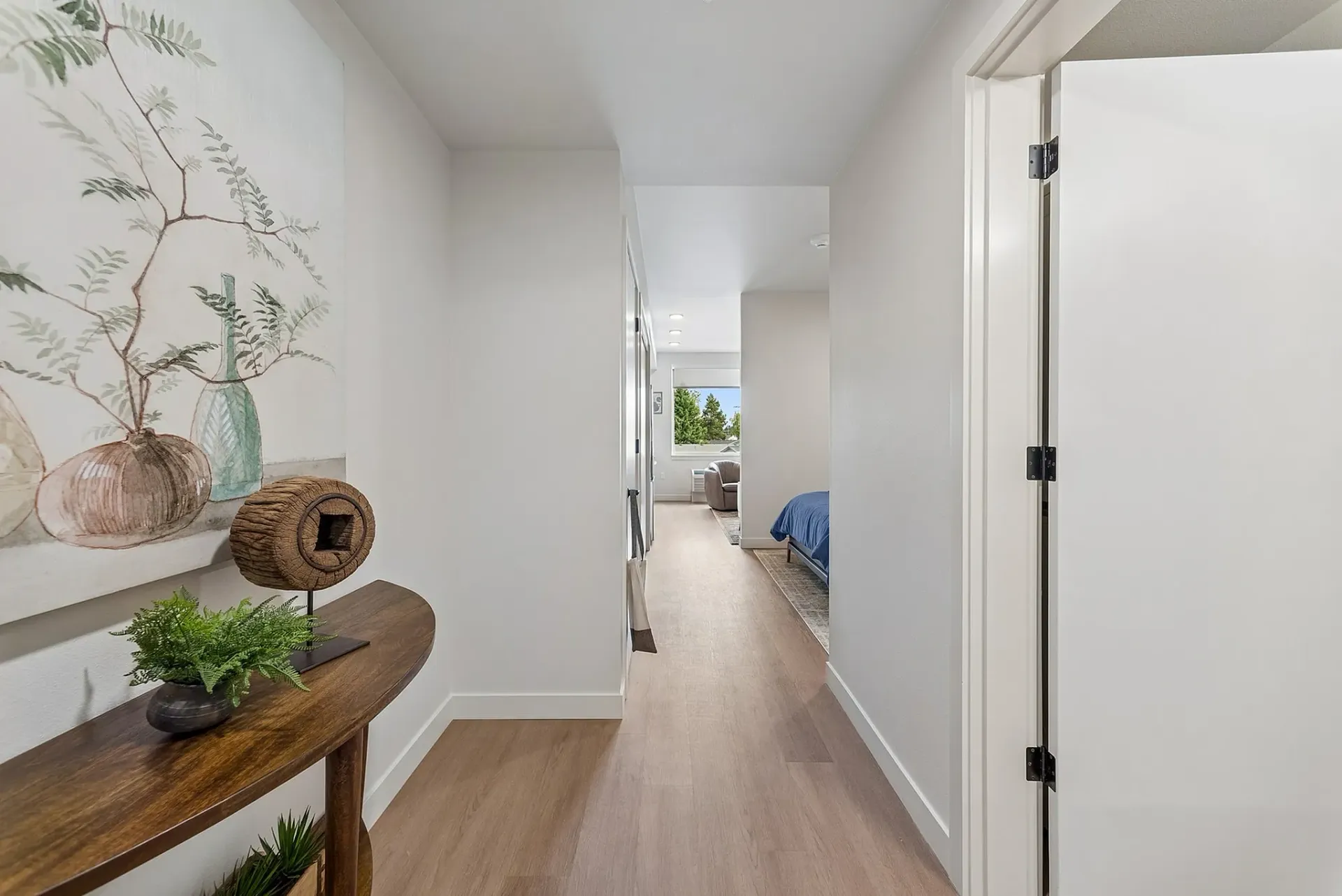 Hallway entrance to apartment unit with decor and view of bedroom