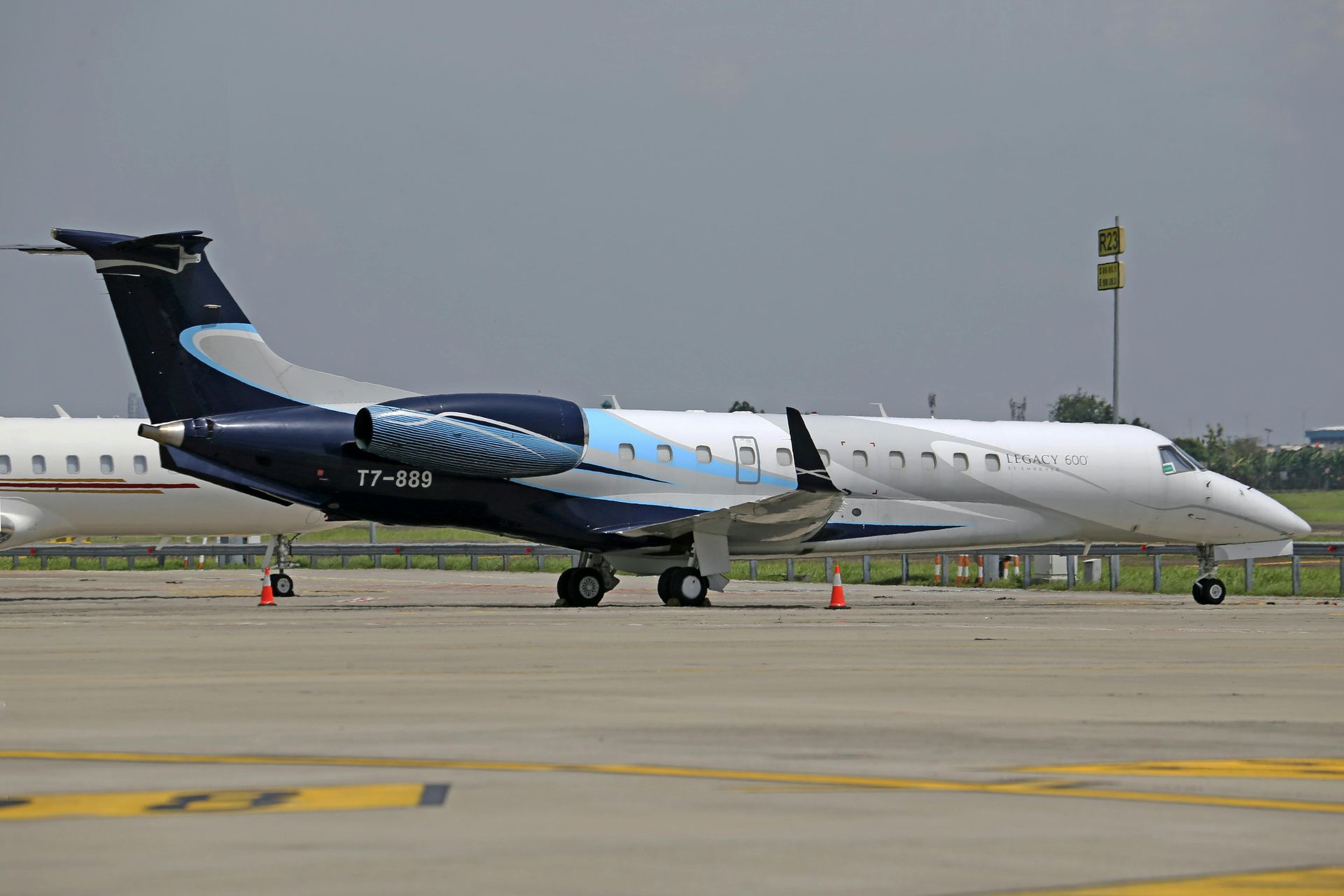 White and blue private jet on the tarmac. Dark blue accents, light blue highlights. Jet Mentis Partners
