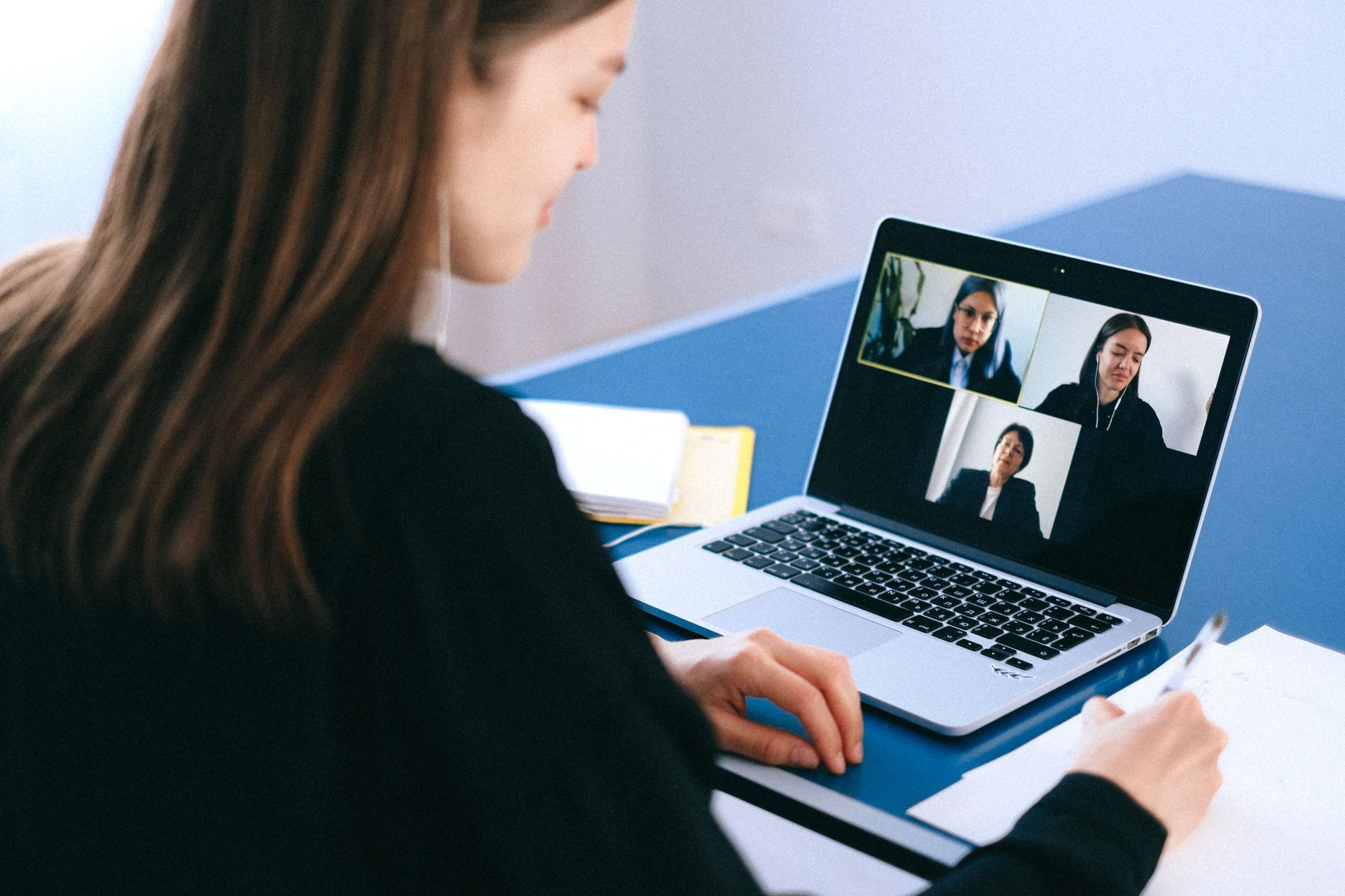 Student taking notes during a live online group discussion