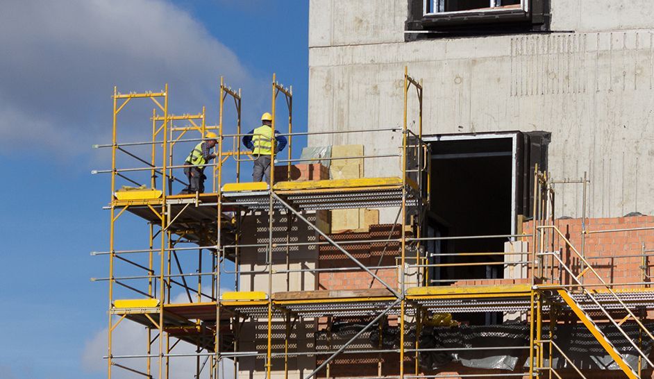 Un groupe d'ouvriers du bâtiment travaille sur un bâtiment en construction.