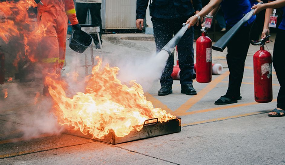 Un groupe de pompiers utilise un extincteur pour éteindre un incendie.