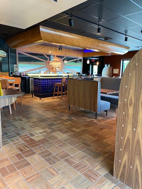 A restaurant with a wooden floor and tables and benches