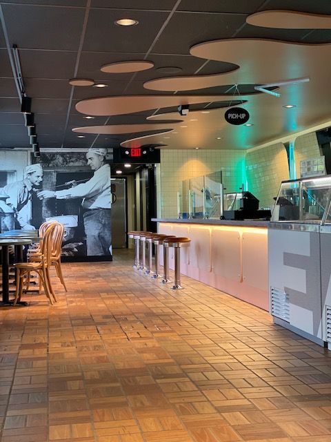 A restaurant with tables and chairs and a sign that says ea