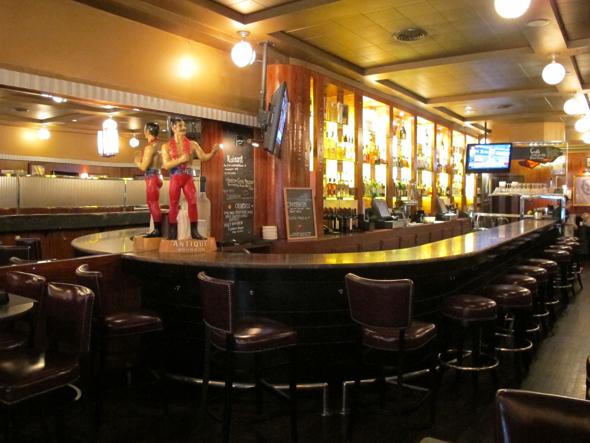 A statue of a man standing on a bar in a restaurant