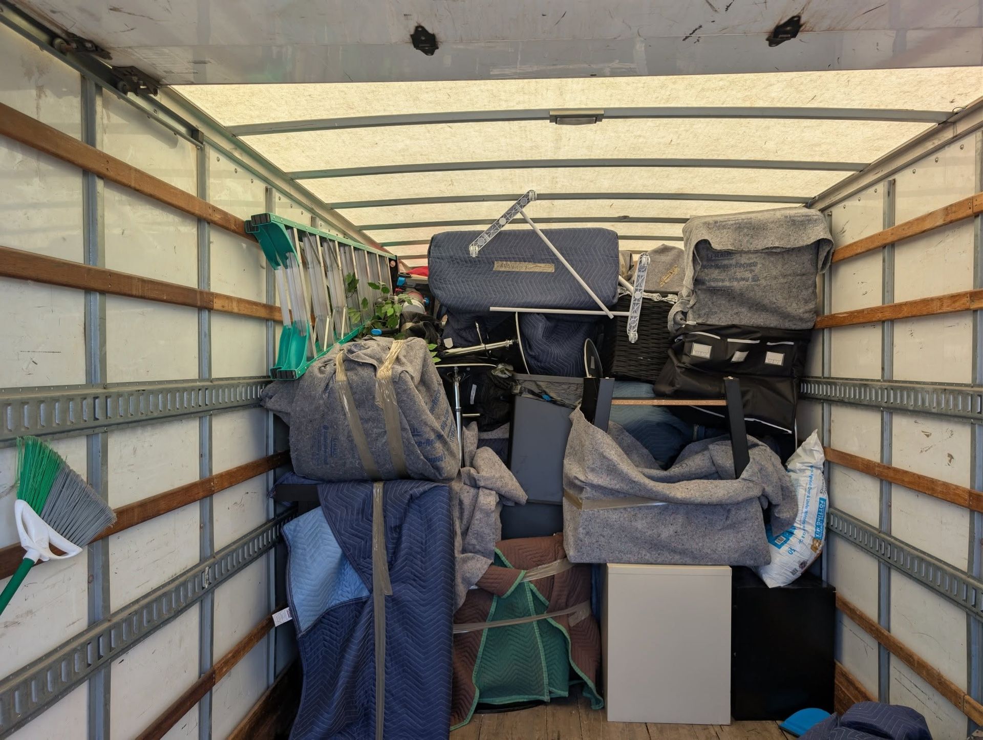 Packed moving truck with stacked furniture and covered boxes inside