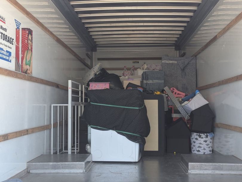 Packed moving truck interior with furniture and boxes loaded to the back of the trailer