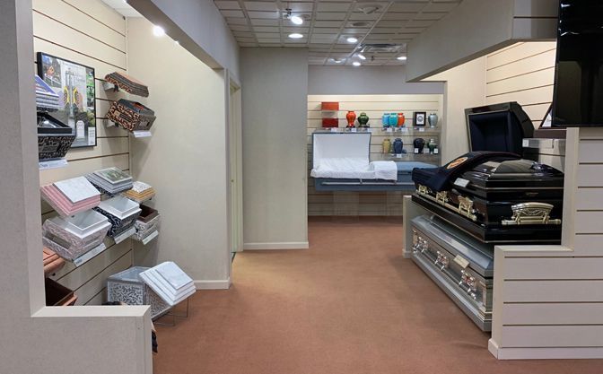 Small retail shop interior with display counters, shelves, and a doorway in the back