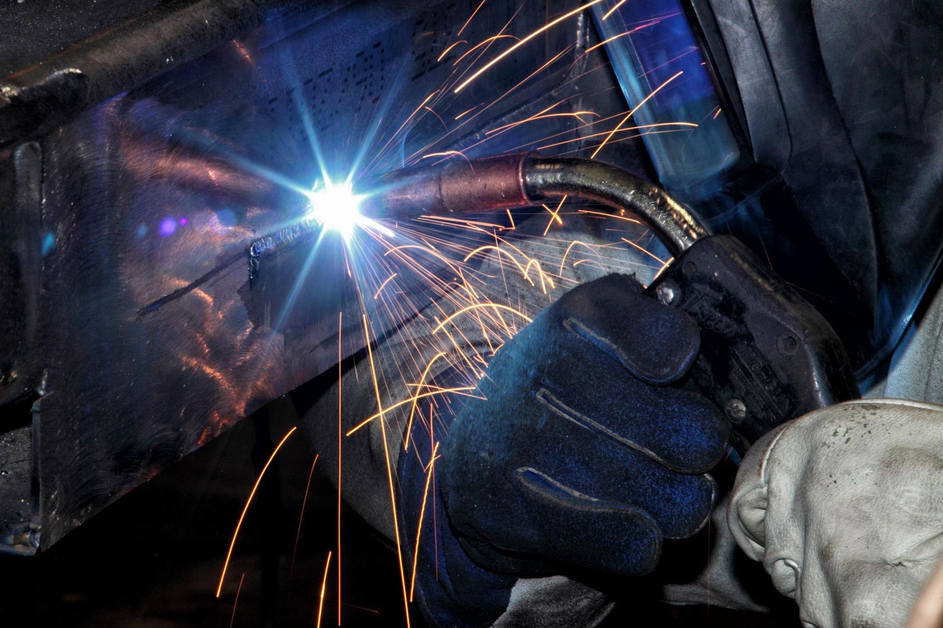 A welder in Phoenix, AZ, expertly performs welding services on a metal object at Advanced Metal Sale