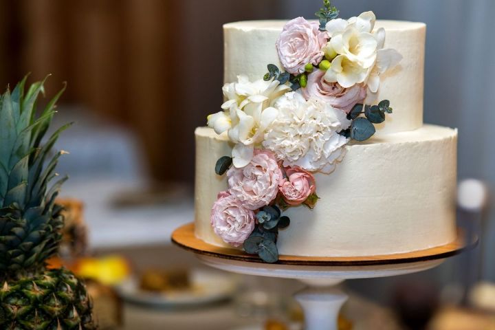 A wedding cake with flowers on it is sitting on a table.