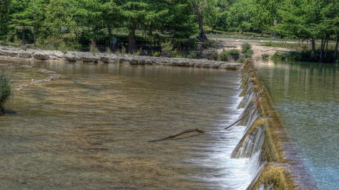 There is a small waterfall in the middle of a river.