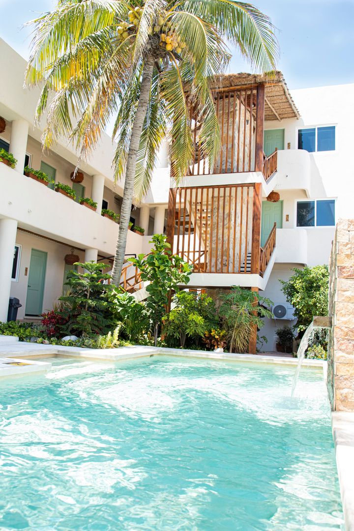 Una gran piscina frente a un edificio con palmeras.