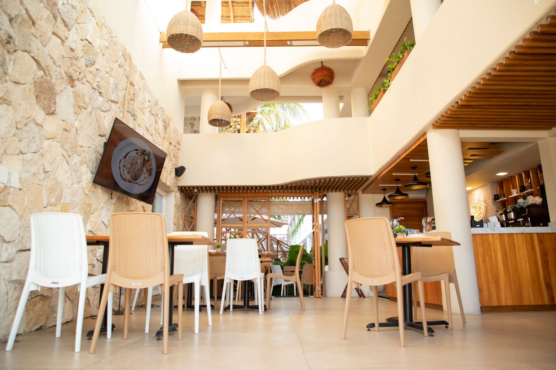 Un restaurante con mesas y sillas y un televisor en la pared.