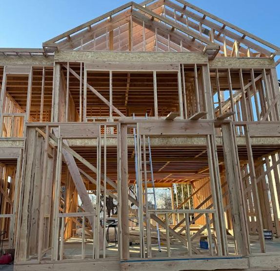 Wooden house frame under construction outdoors.