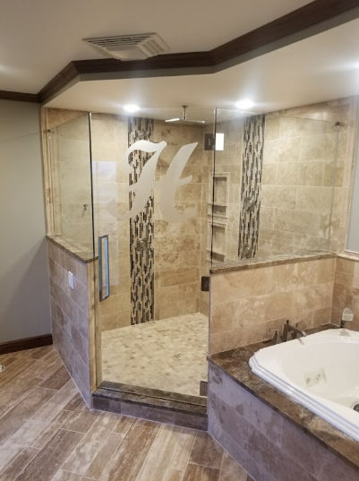 Luxury bathroom with beige tile, glass shower enclosure, and a corner bathtub