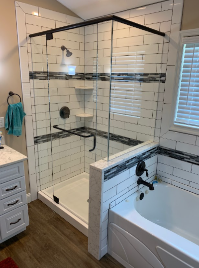 Modern bathroom with a glass walk-in shower, white subway tile, and a bathtub beside it