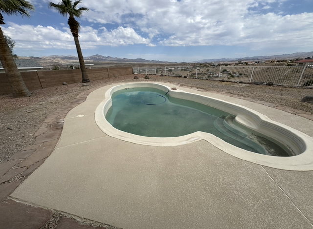 Wooden deck surrounds a turquoise pool with built-in steps.