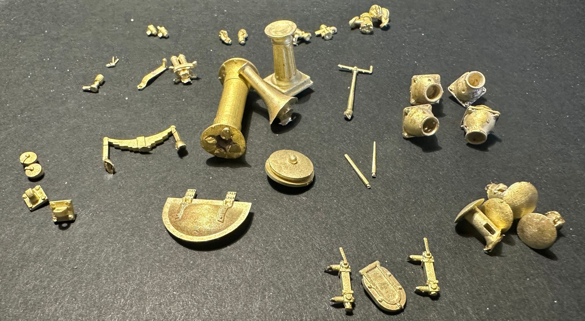 A bunch of brass pieces with letters t and v on them