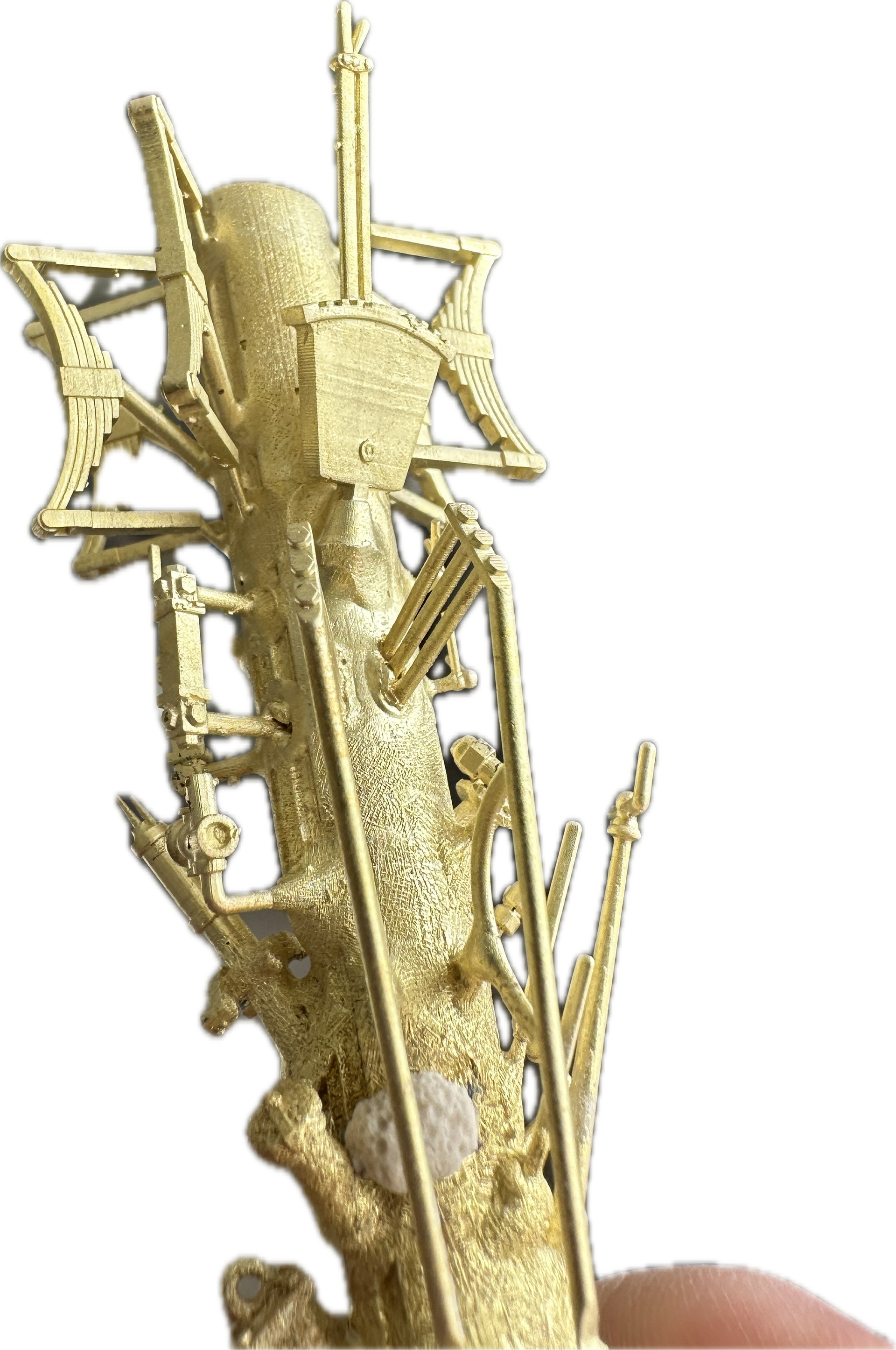A person is holding a gold object in their hand.