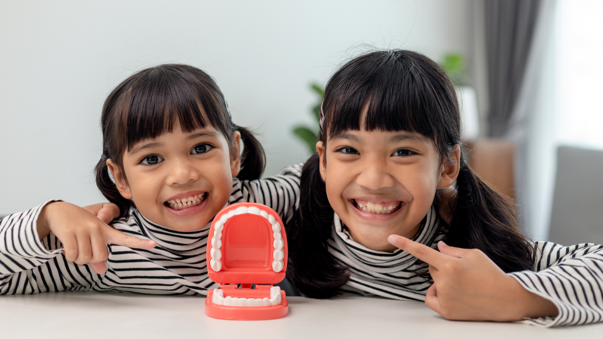 kids smiling and playing with dentures