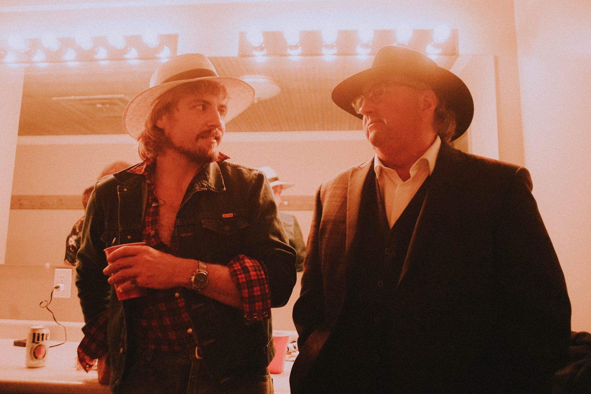 Two men wearing hats are standing next to each other