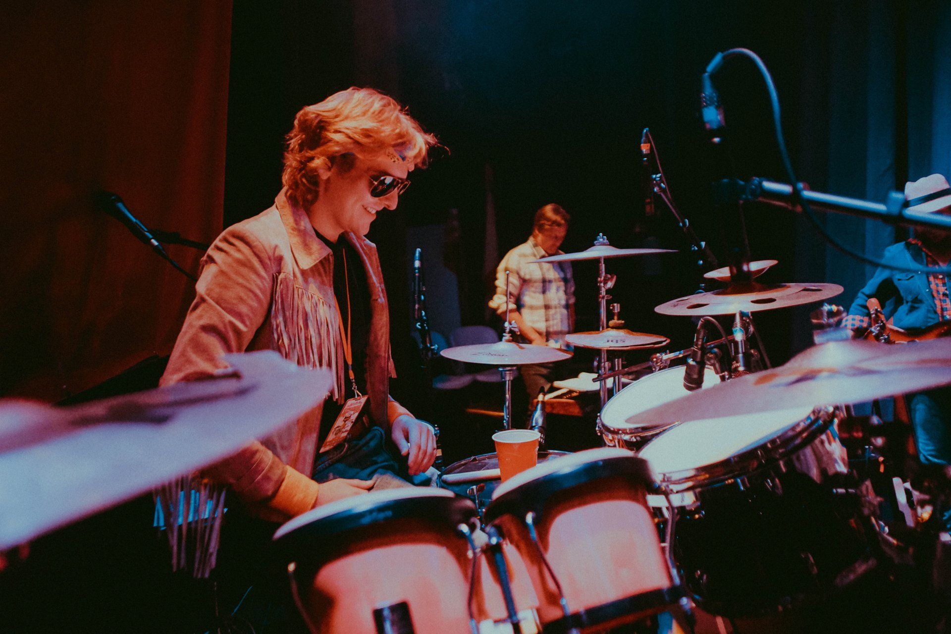 A man playing drums in front of a microphone