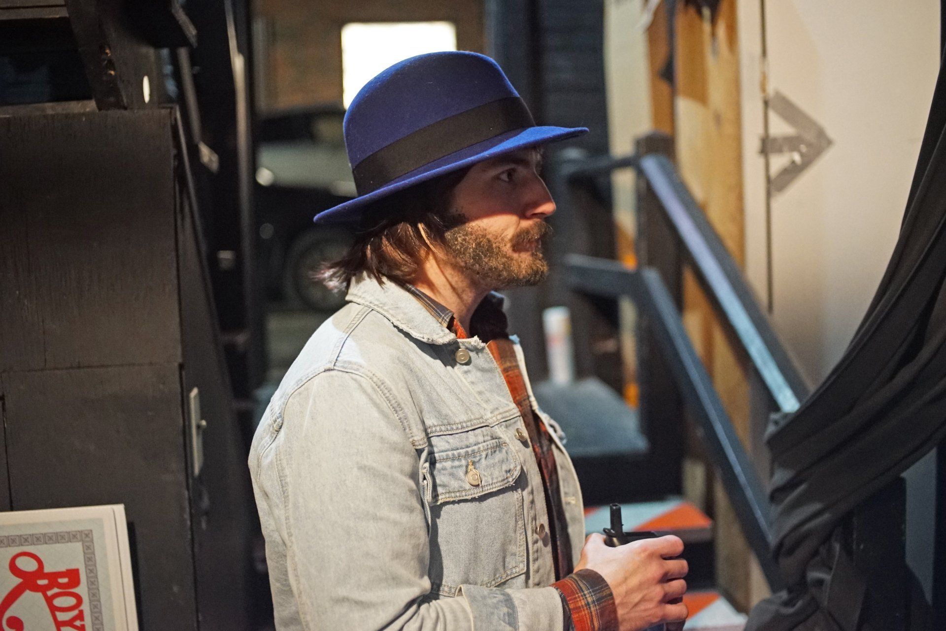 A man wearing a blue hat and a denim jacket