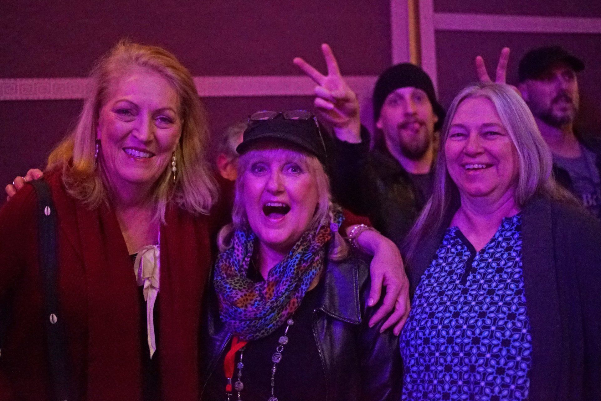 A group of people are posing for a picture in a dark room.