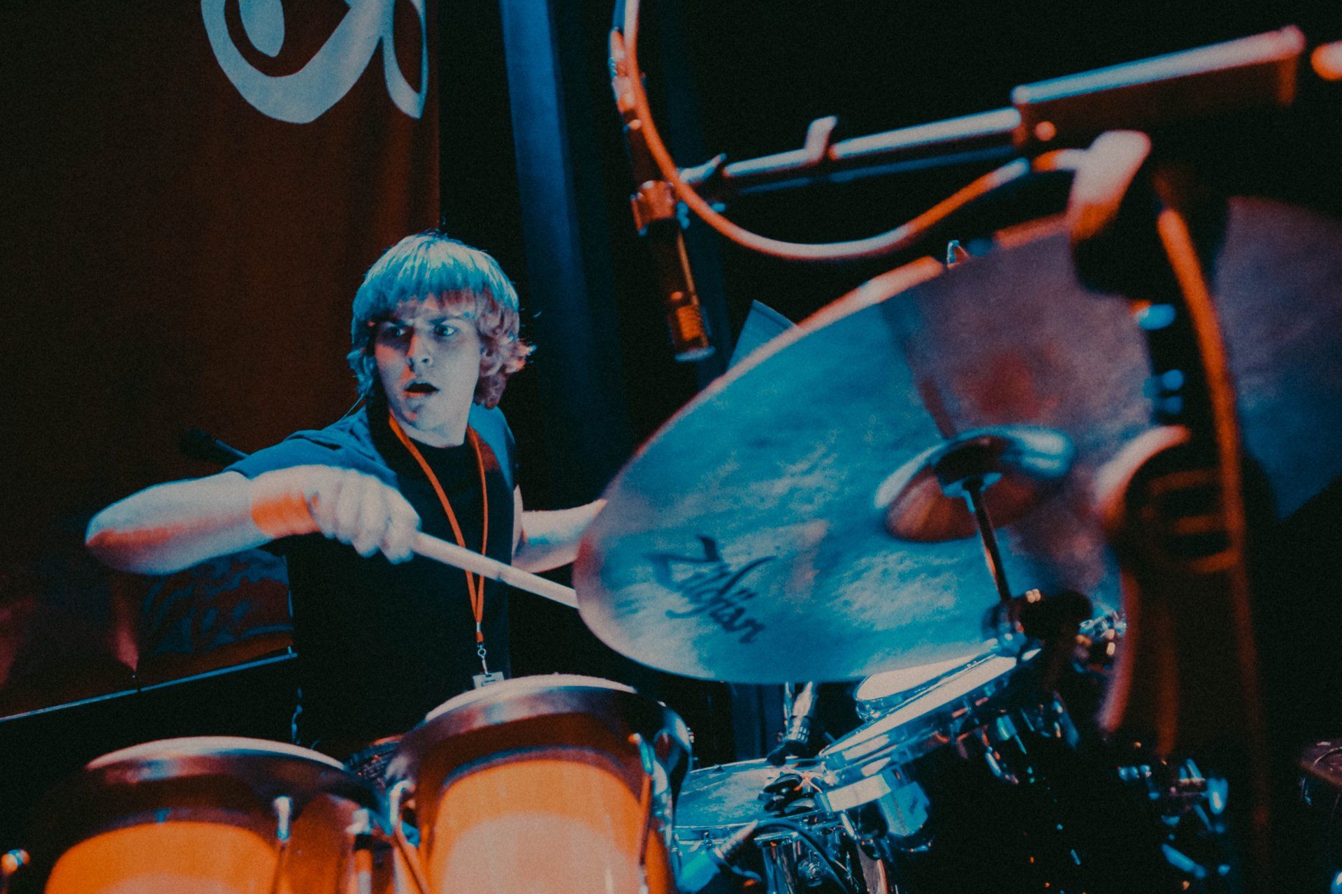 A man playing drums with a cymbal that says sabian on it
