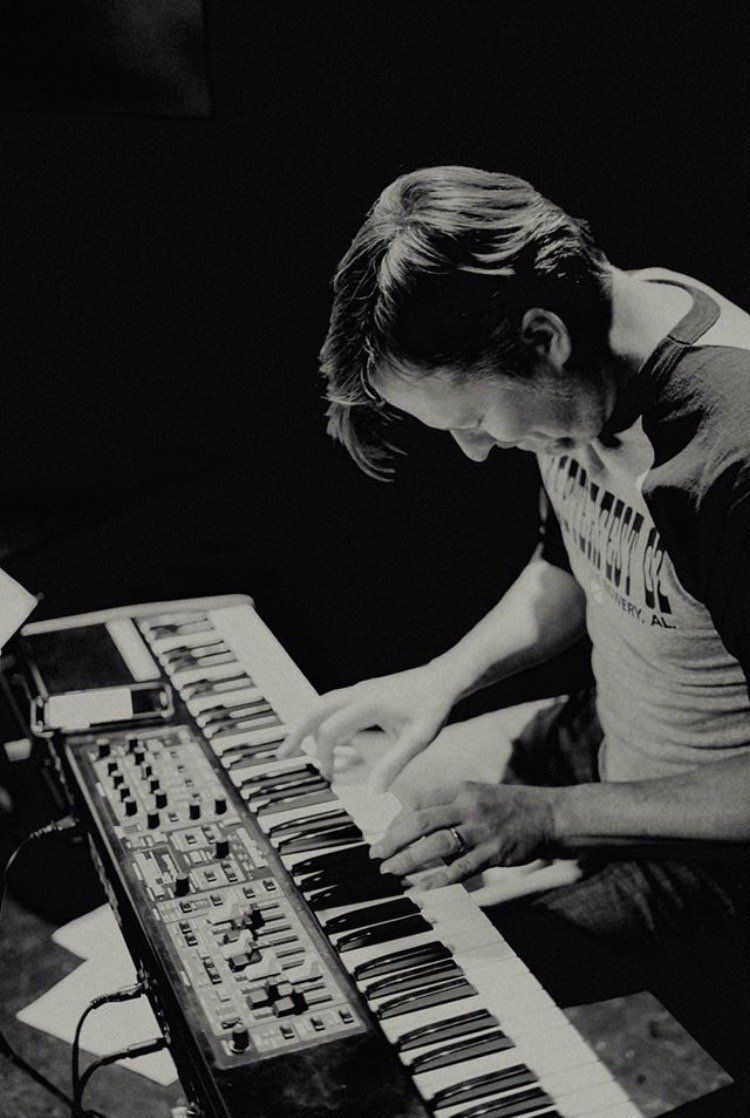 A man is playing a keyboard in a black and white photo