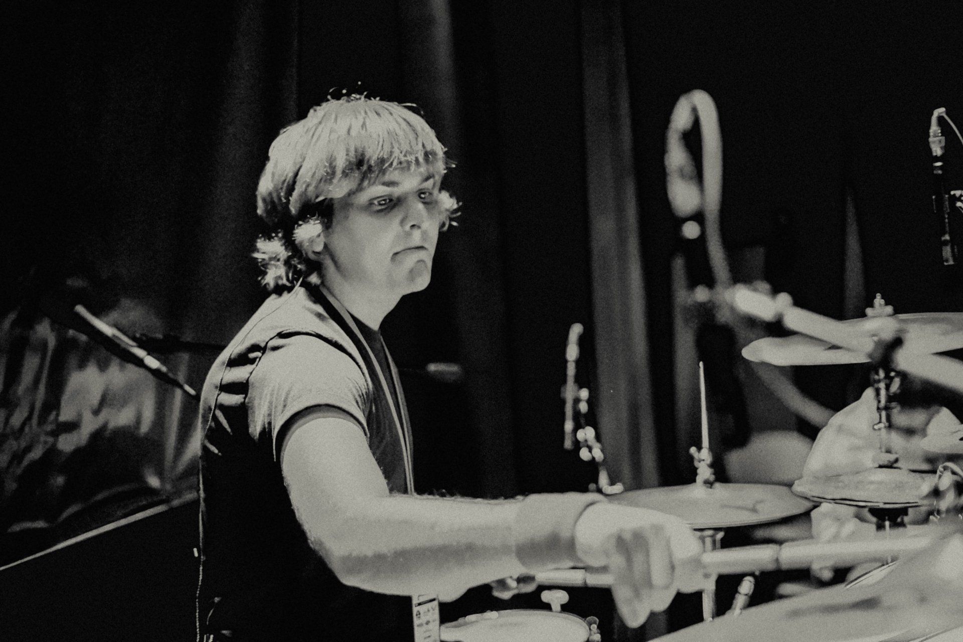 A man is playing drums in a black and white photo