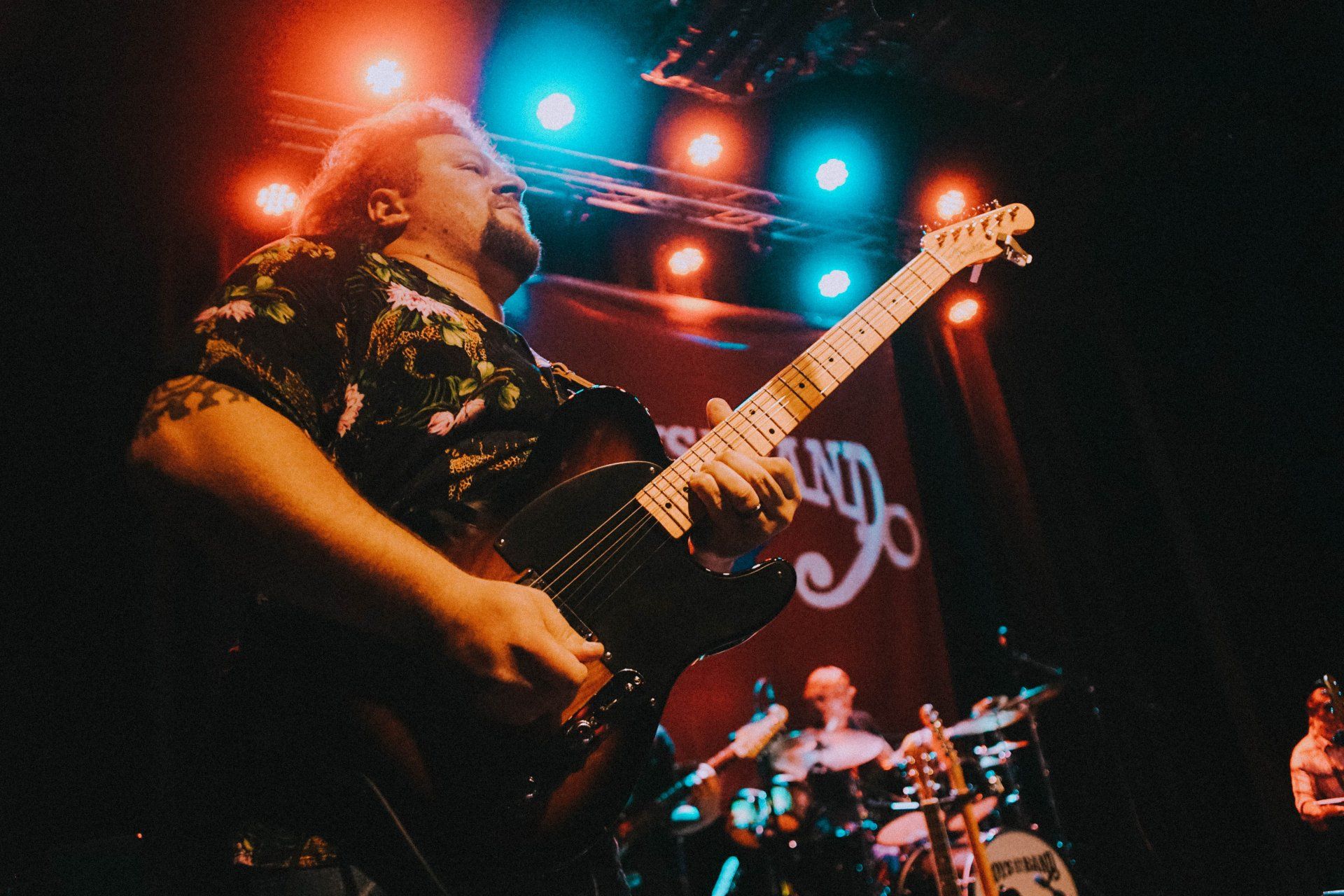 A man is playing a guitar on a stage.