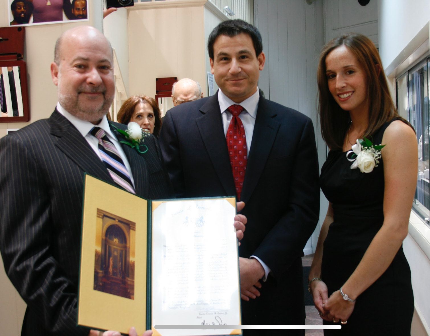 A man in a suit and tie is holding a certificate