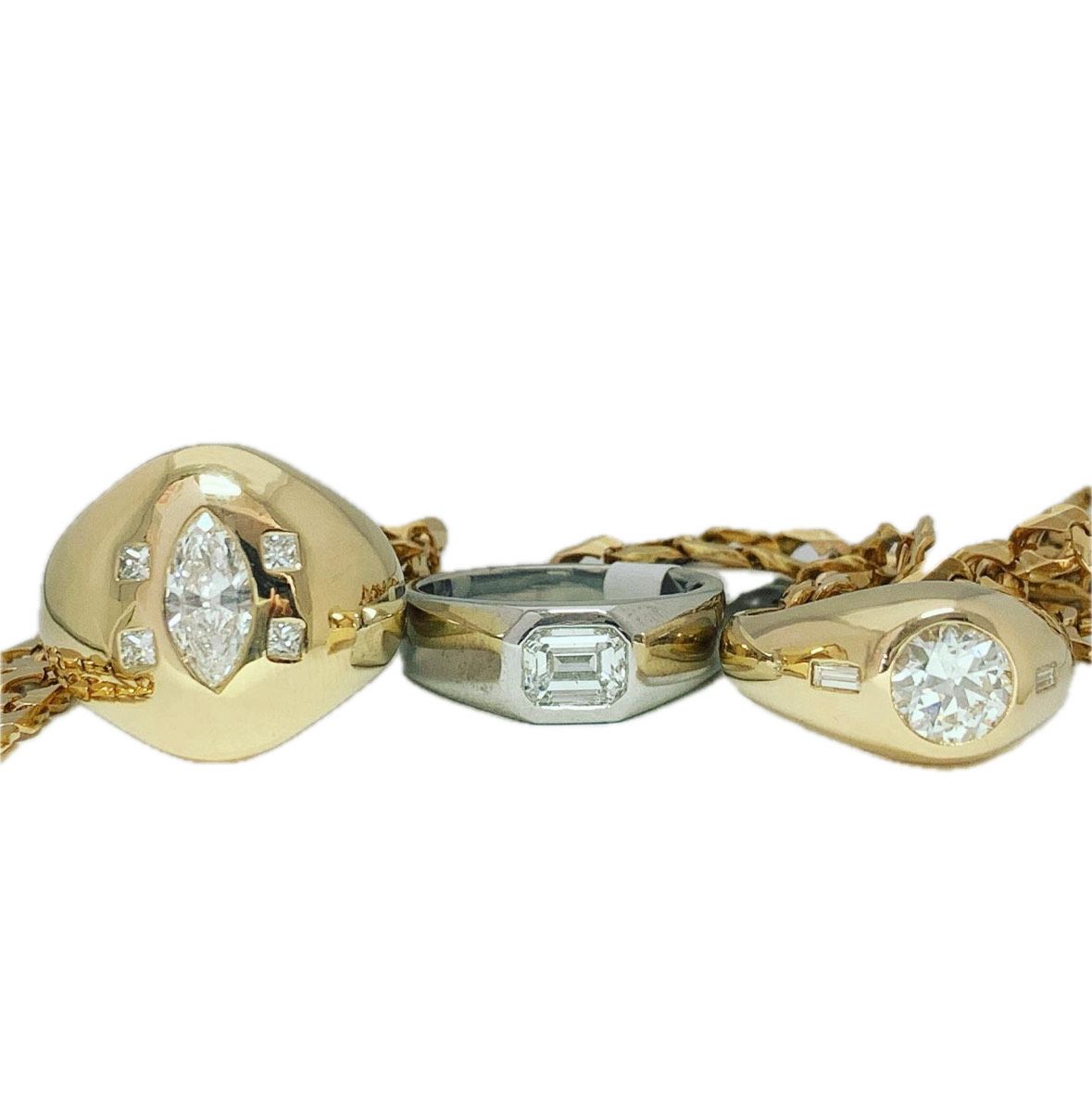 Three gold rings are sitting on a white surface