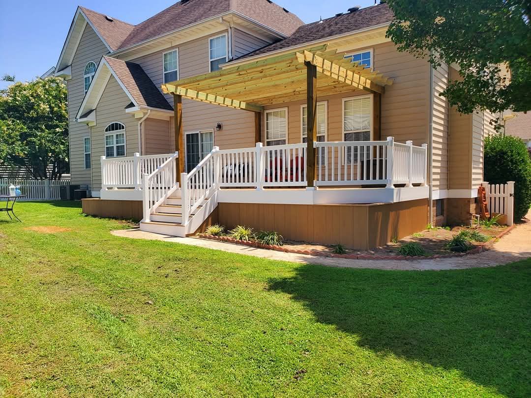Yellow house with white porch and steps, front lawn, and shaded trees