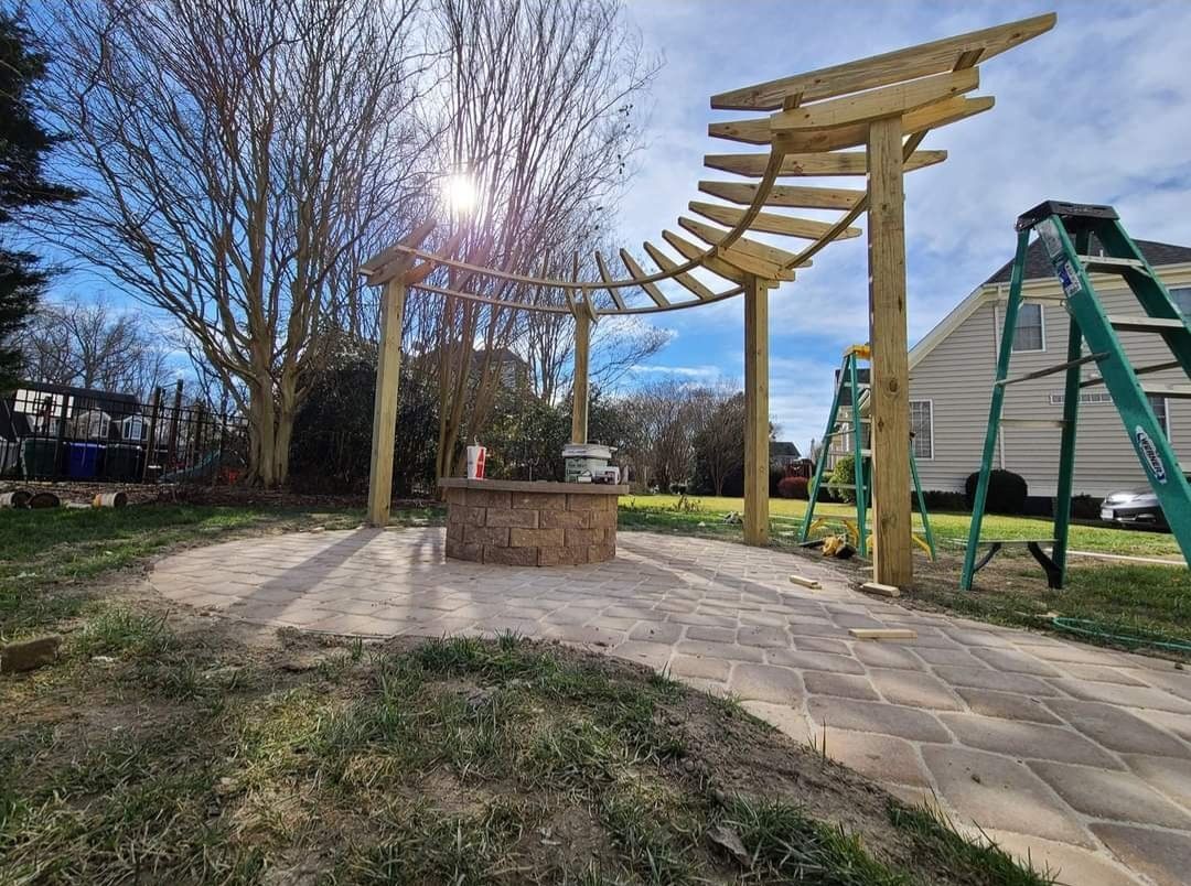Modern outdoor playground with wooden climbing structure, slide, and paved path on a sunny day