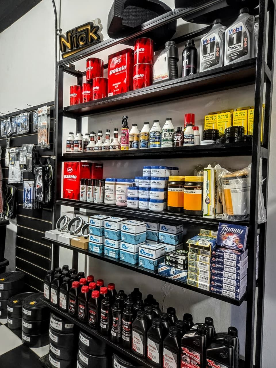 Estanterías con aceites para automóviles y productos para el cuidado del automóvil en un pasillo de una tienda.